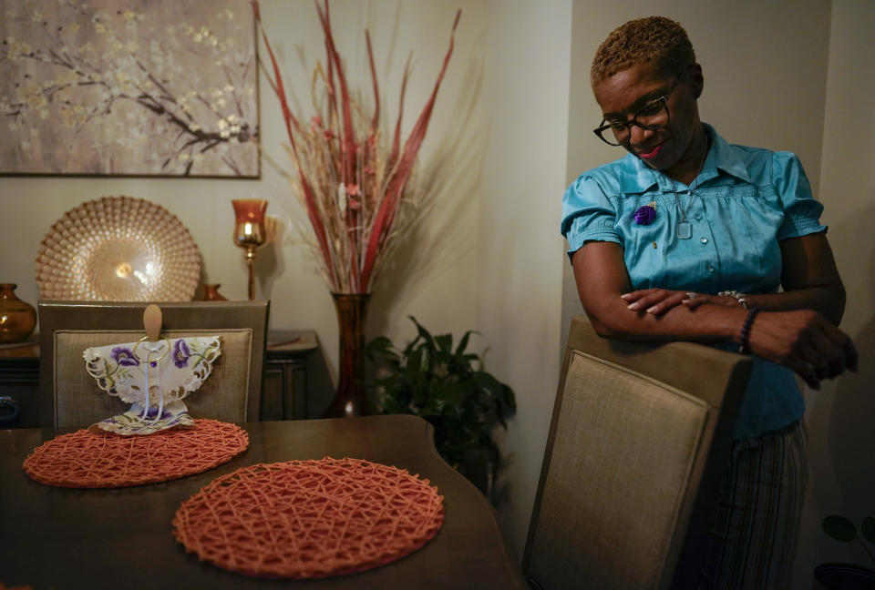 Nadine Thomas pauses as she talks about her daughter Nikiesha Thomas at her dining room table in Olney, Md., Thursday, Aug. 25, 2022, and the angel with purple flowers were given to her after Nikiesha was shot and killed by her ex-boyfriend just days after filing for a protective order last October. Victims of abuse and their families saw a quiet breakthrough this summer when the passage of a bipartisan gun safety bill in Congress included a proposal that would make it more difficult for intimate partners of convicted domestic abusers to obtain firearms. (AP Photo/Carolyn Kaster)