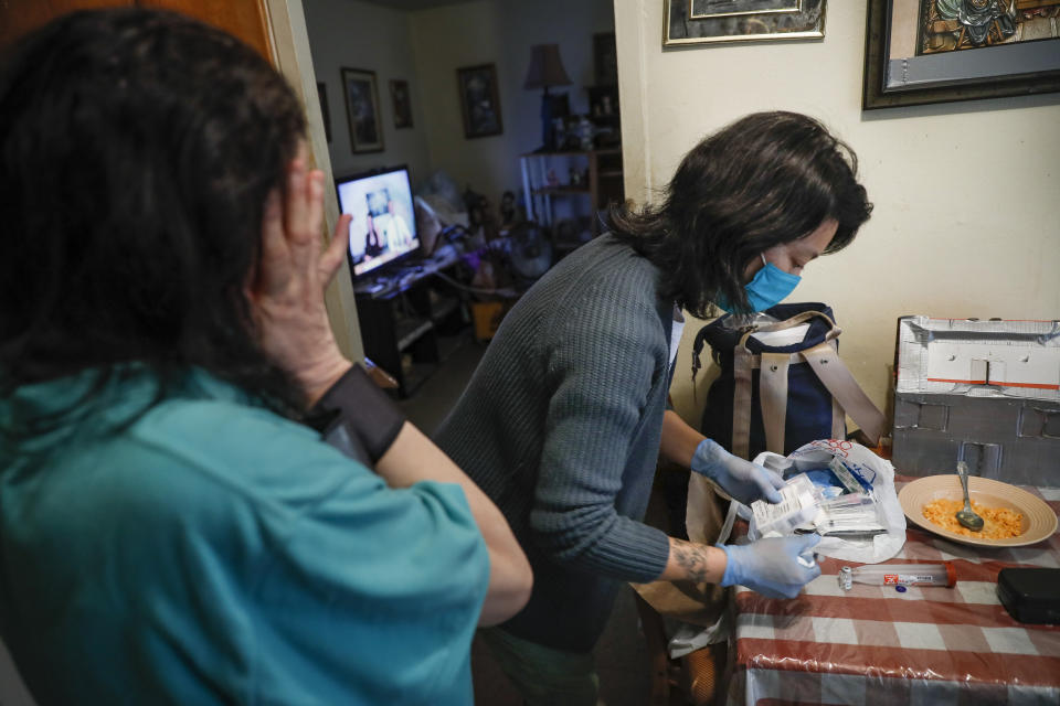 Dr. Jeanie Tse, chief medical officer at the Institute for Community Living, gathers her prescription items after she administers antipsychotic medication to a patient living with schizophrenia in her home at a public housing complex, Wednesday, May 6, 2020, in the Brooklyn borough of New York. (AP Photo/John Minchillo)