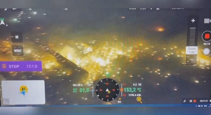 A view of a screen showing a white burning substance descending on buildings.