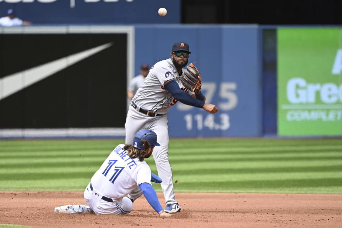 Detroit Tigers second baseman Willi Castro, top, throws to first base to put out Toronto Blue Jays' Teoscar Hernandez after forcing out Bo Bichette, bottom, at second base in the fourth inning of a baseball game in Toronto, Sunday, July 31, 2022. (Jon Blacker/The Canadian Press via AP)