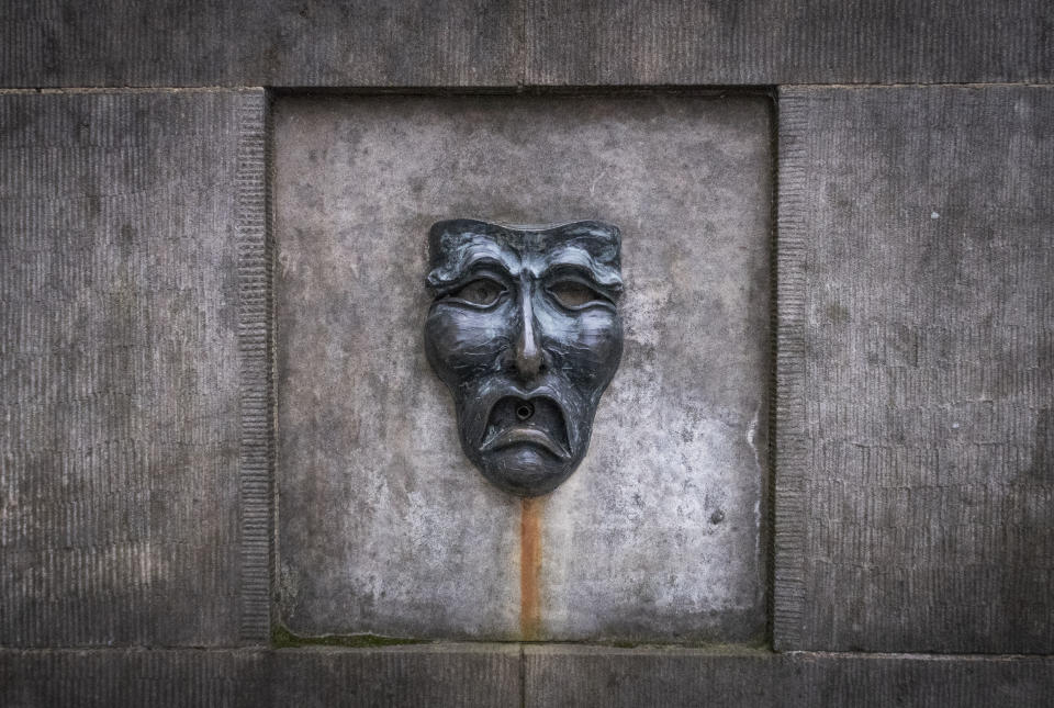 A bronze theatre mask on Edinburgh's Royal Mile, in Edinburgh, Scotland, Wednesday April 1, 2020. Every August, the Scottish capital of Edinburgh plays host to some of the funniest and talented — not to forget the strangest — artists from the U.K. and the wider world. Not this year, as organizers made the decision Wednesday to cancel the city's festivals as a result of the coronavirus pandemic. (Jane Barlow/PA via AP)