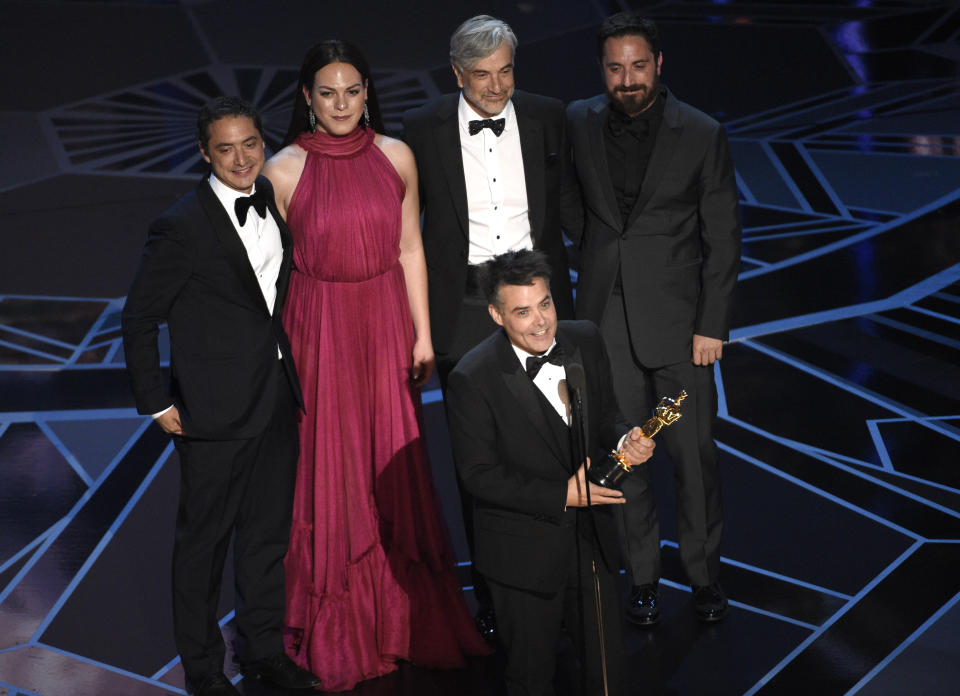 FILE - In this March 4, 2018 file photo, Sebastian Lelio, foreground center, and Juan de Dios Larrain, background left, transgender actress Daniela Vega, Francisco Reyes, and Pablo Larrain accept the award for best foreign language film for "A Fantastic Woman" at the Oscars in Los Angeles. Nick Adams, director of the transgender media program at GLAAD, the LGBT advocacy group, says that victory was significant for the struggle for more prominent trans representation in movies. (Photo by Chris Pizzello/Invision/AP, File)