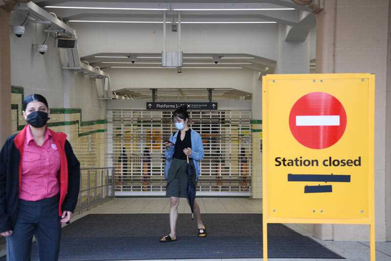 Commuters arrive at the closed Central Station during the shutdown of Sydney's train network in Sydney.