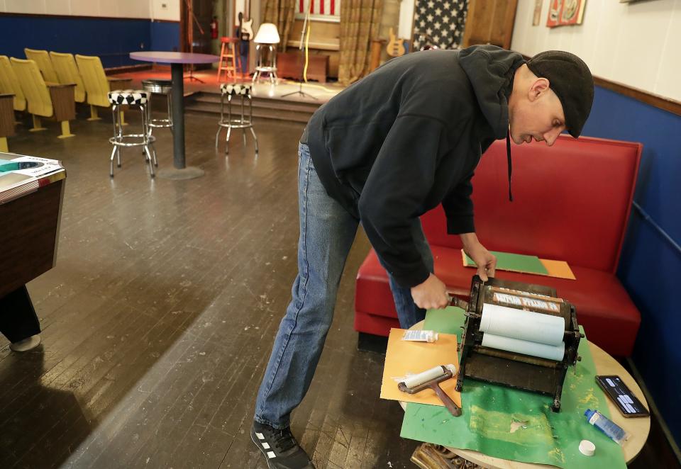 Owner Greg Vande Hey hand prints concert posters at the Vaudette on Friday, March 10, 2023 in Kaukauna, Wis.