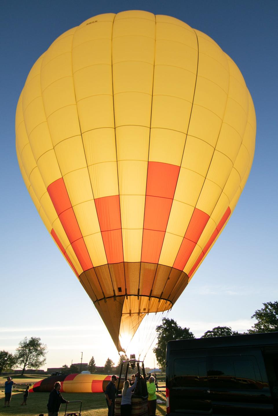 The hot-air balloon Overheat, still tethered to the ground, prepares to launch Friday, June 24, 2022 in what would be a flight lasting about an hour and a half and moving about a quarter mile due to navigating varying wind patterns to keep the nearly directly over the point of launch.