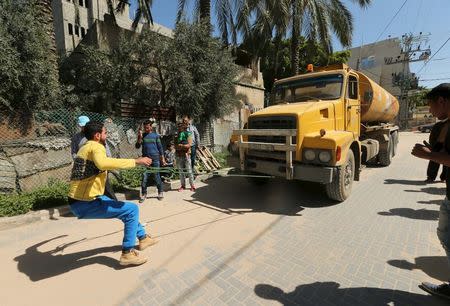 Palestinian Mohammad Baraka, 20, nicknamed by people as Gaza Samson, pulls a fuel tanker by a rope as he exercises in Deir al-Balah in the central Gaza Strip March 5, 2016. REUTERS/Mohammed Salem