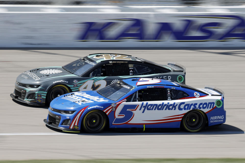Kyle Larson (5) passes Noah Gragson as they head down the front straightaway during a NASCAR Cup Series auto race at Kansas Speedway in Kansas City, Kan., Sunday, May 7, 2023. (AP Photo/Colin E. Braley)