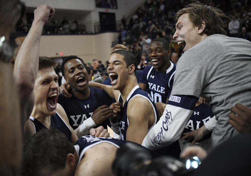 Yale basketball players celebrate their Ivy League championship win over Harvard after an NCAA college basketball game at Yale University in New Haven, Conn., Sunday, March 17, 2019, in New Haven, Conn. (AP Photo/Jessica Hill)