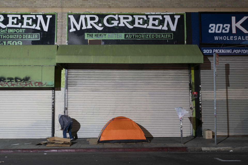 FILE - A homeless man stands next to his tent in Los Angeles, Wednesday, Dec. 14, 2022. Los Angeles. President Joe Biden's Administration announced Monday, Dec. 19 it is ramping up efforts to help house people now sleeping on sidewalks, in tents and cars as a new federal report confirms what's obvious to people in many cities: Homelessness is persisting despite increased local efforts. (AP Photo/Jae C. Hong, File)