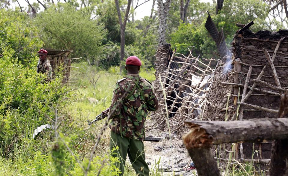 Policemen stand guard at a homestead after gunmen attacked Hindi village, near Lamu