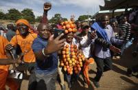 <p>A supporter of opposition leader Raila Odinga wears a headdress of oranges, the party color, as they gather in advance of a mock “swearing-in” ceremony of Odinga at Uhuru Park in downtown Nairobi, Kenya Tuesday, Jan. 30, 2018. (Photo: Ben Curtis/AP) </p>