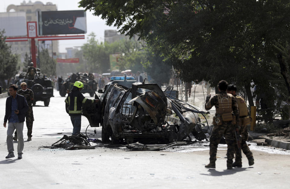 Afghan security personnel inspect the site of a bomb explosion in Kabul, Afghanistan, Saturday, June 12, 2021. Separate bombs hit two minivans in a mostly Shiite neighborhood in the Afghan capital Saturday, killing several people and wounding others, the Interior Ministry said. (AP Photo/Rahmat Gul)