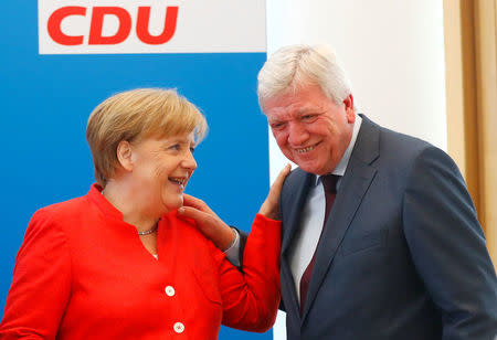 German Chancellor Angela Merkel and Volker Bouffier react as they attend the board meeting of Germany's Christian Democratic Union (CDU) in Berlin, Germany, June 18 2018. REUTERS/Hannibal Hanschke