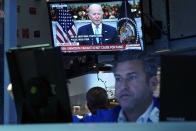 President Jose Biden appears on a screen as trader Glenn Kessler works on the floor of the New York Stock Exchange, Monday, Nov. 29, 2021. President Joe Biden urged Americans to get vaccinated including booster shots as he sought to quell concerns Monday over the new COVID-19 variant omicron. (AP Photo/Richard Drew)