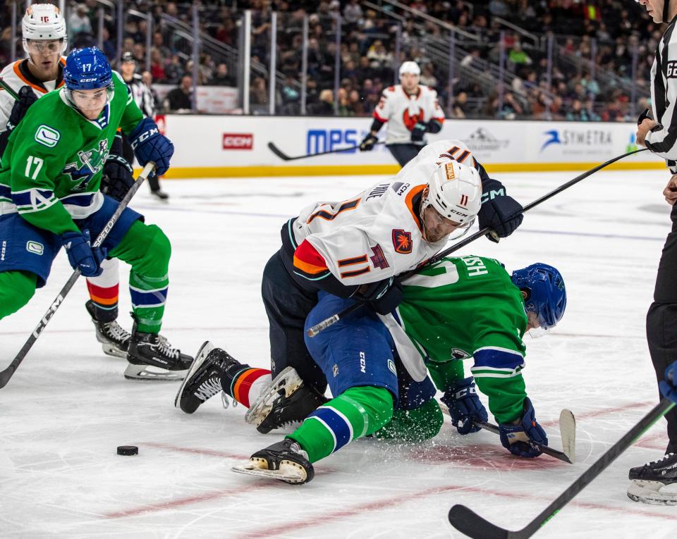 Firebirds forward Alexander True (11) and Canucks forward Michael Regush (72) fall to the ice during a face off during the second period of their game at Climate Pledge Arena in Seattle, Wash., Sunday, Oct. 23, 2022. 