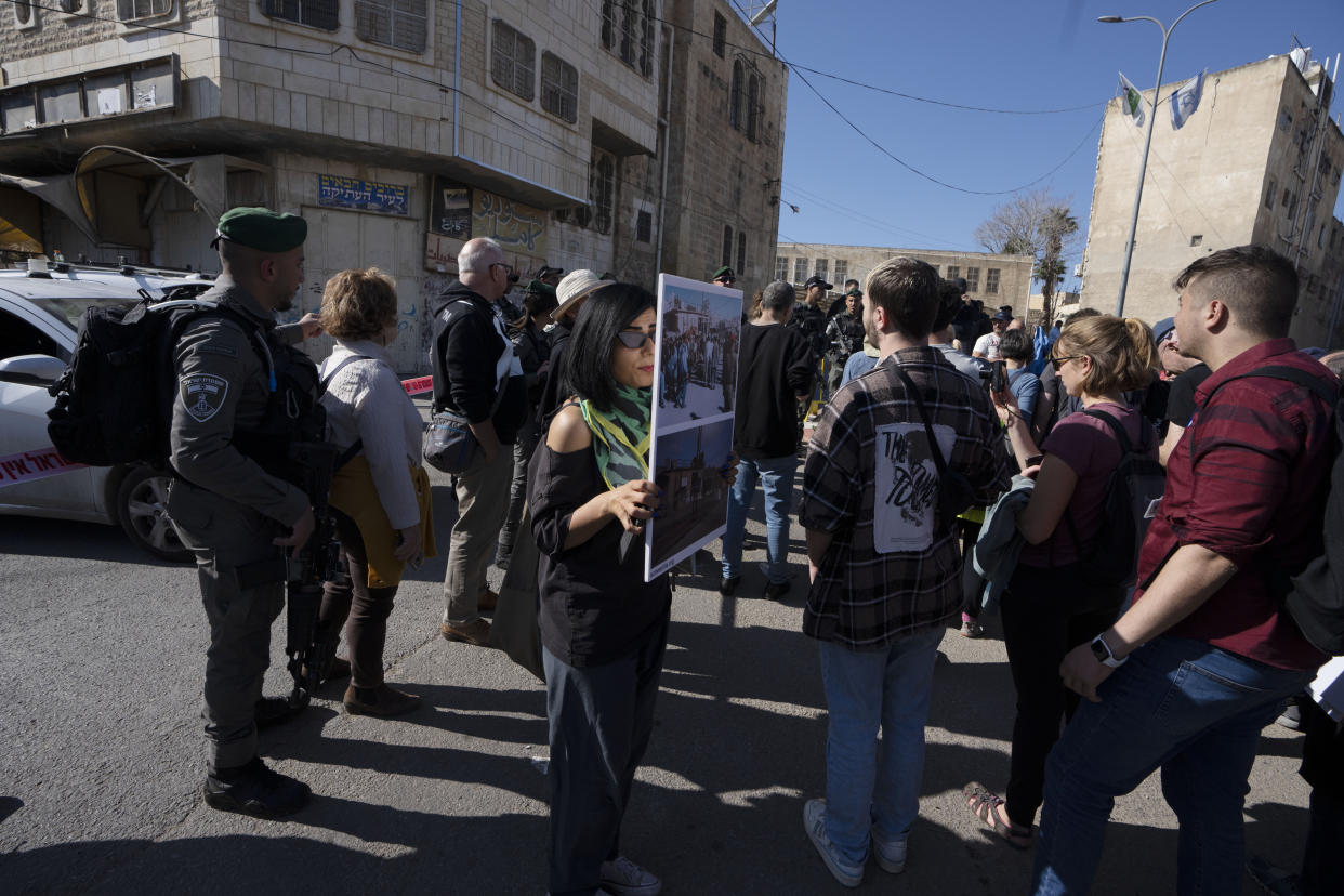 Israeli peace activists activist take part in a "solidarity tour" of the embattled West Bank city of Hebron, Friday, Dec. 2, 2022. Israeli peace activists toured the occupied West Bank's largest city Friday in a show of solidarity with Palestinians, amid chants of "shame, shame" from ultra-nationalist hecklers. The encounter in the center of Hebron signaled the widening rift among Israelis over the nature of their society and Israel's open-ended military rule over the Palestinians, now in its 56th year. (AP Photo/ Maya Alleruzzo)