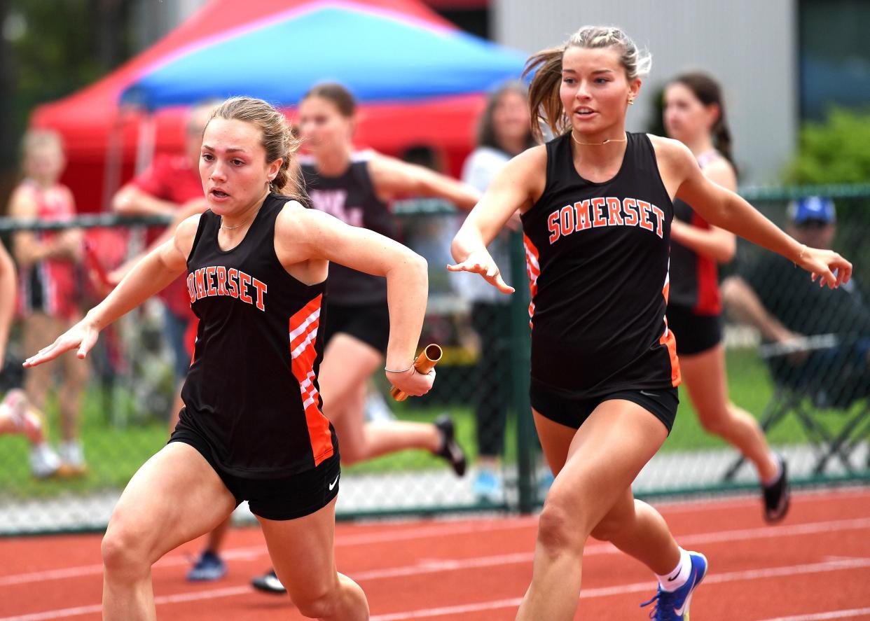 Somerset's Kamryn Ross, left, takes the baton from Abby Urban and goes on to win the girls 4x100 relay in come-from-behind fashion with a time of 50.24 during the LHAC track and field championships, May 7, at St. Francis University.