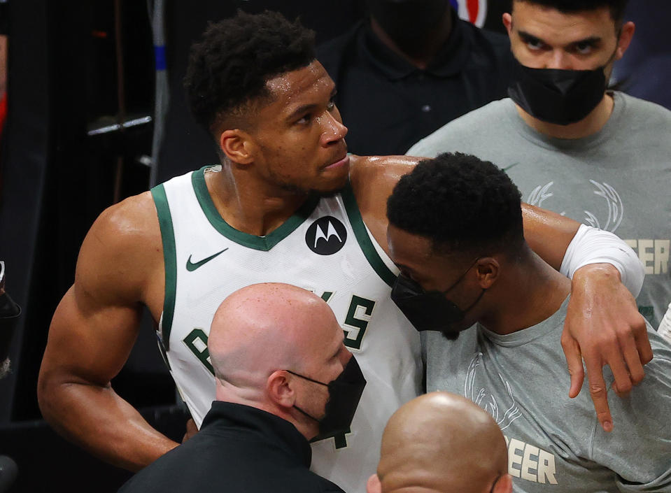 Giannis Antetokounmpo is helped off the court after hyperextending his knee during Game 4 of the Eastern Conference finals at State Farm Arena in Atlanta on June 29, 2021. (Kevin C. Cox/Getty Images)