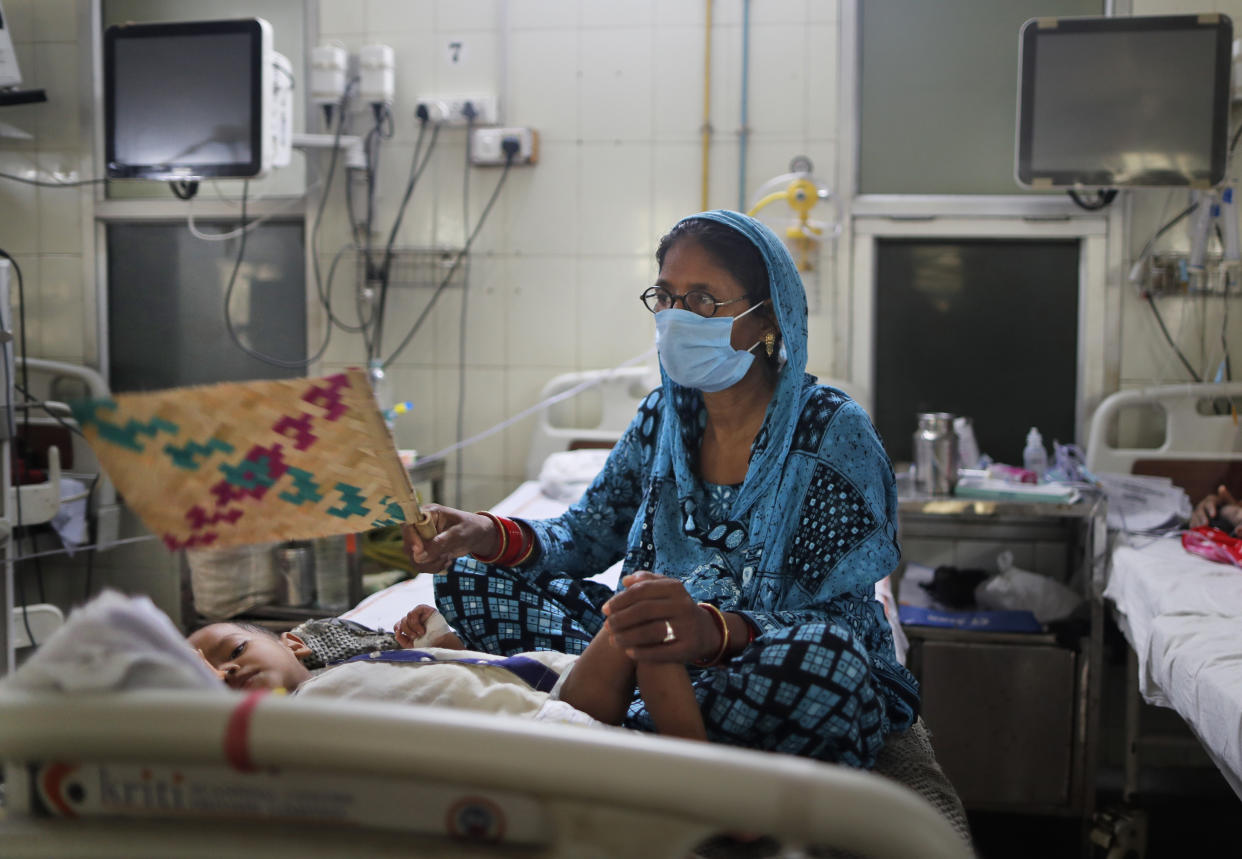 A woman fans her sick child at the Sarojini Naidu Childrens Hospital, in Prayagraj, Uttar Pradesh, India, Monday, Sept. 6, 2021. The annual monsoon season brings a spurt in mosquito-borne diseases overcrowding hospitals in most parts of India. (AP Photo/Rajesh Kumar Singh)