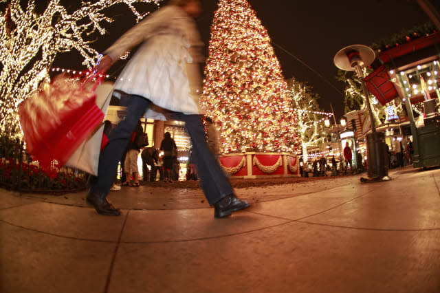 Pedestrian with shopping bags walking in downtown shopping area at Christmas