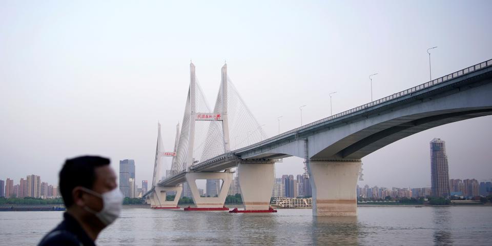 FILE PHOTO: A man wearing a face mask is seen under a bridge of Yangtze river in Wuhan after the lockdown was lifted in Wuhan, capital of Hubei province and China's epicentre of the novel coronavirus disease (COVID-19) outbreak, April 15, 2020. REUTERS/Aly Song/File Photo