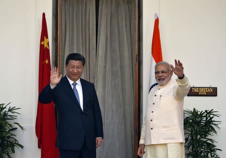 India's Prime Minister Narendra Modi (R) and China's President Xi Jinping wave to the media during a photo opportunity ahead of their meeting at Hyderabad House in New Delhi September 18, 2014. REUTERS/Ahmad Masood