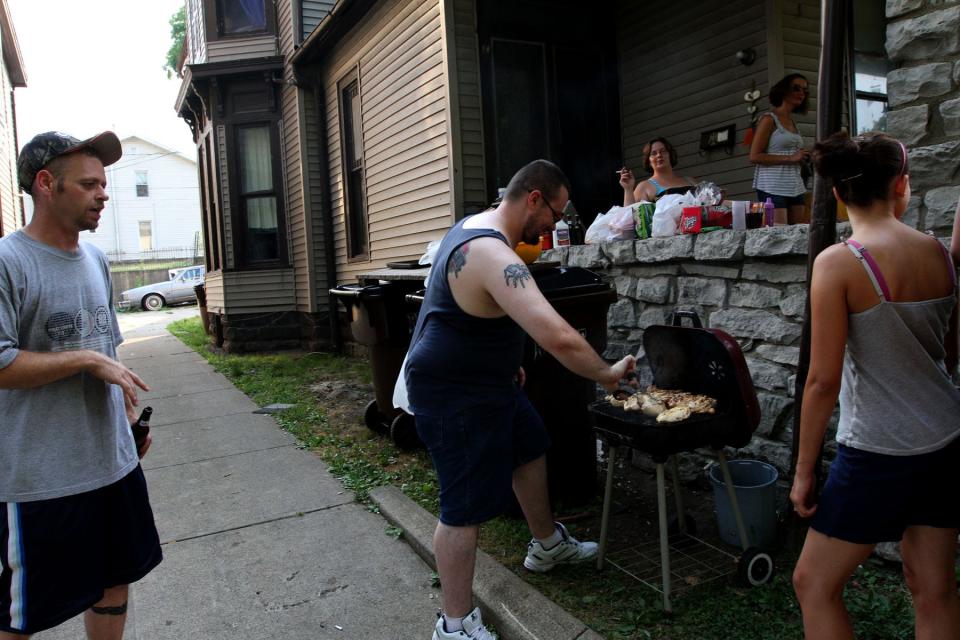 Family and friends gather at the home of Lucretia Granger, 59, to cook food on the grill while the power is out on Hudson Avenue in Newark, Ohio on Saturday, June 30, 2012. A severe storm swept through the night before causing a loss of power for much of the state. Zach Gray/The Advocate