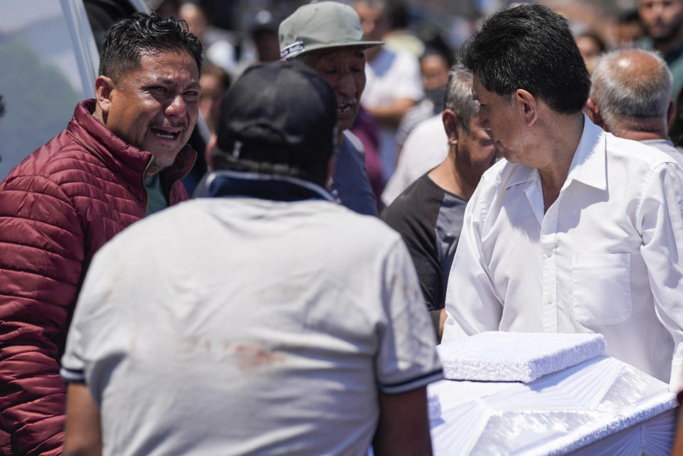 A relative mourns as funeral workers carry the coffin that contain the remains of an 8-year-old girl, in Taxco, Mexico, Thursday, March 28, 2024. The 8-year-old girl disappeared Wednesday; her body was found on a road on the outskirts of the city early Thursday. (AP Photo/Fernando Llano)