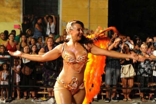 El tronar de los tambores de madera y cuero en estrecha comunión con el sensual movimiento de las bailarinas y 'vedettes' de cada una de las comparsas, era seguido con algarabía por miles de espectadores. (AFP | Miguel Rojo)