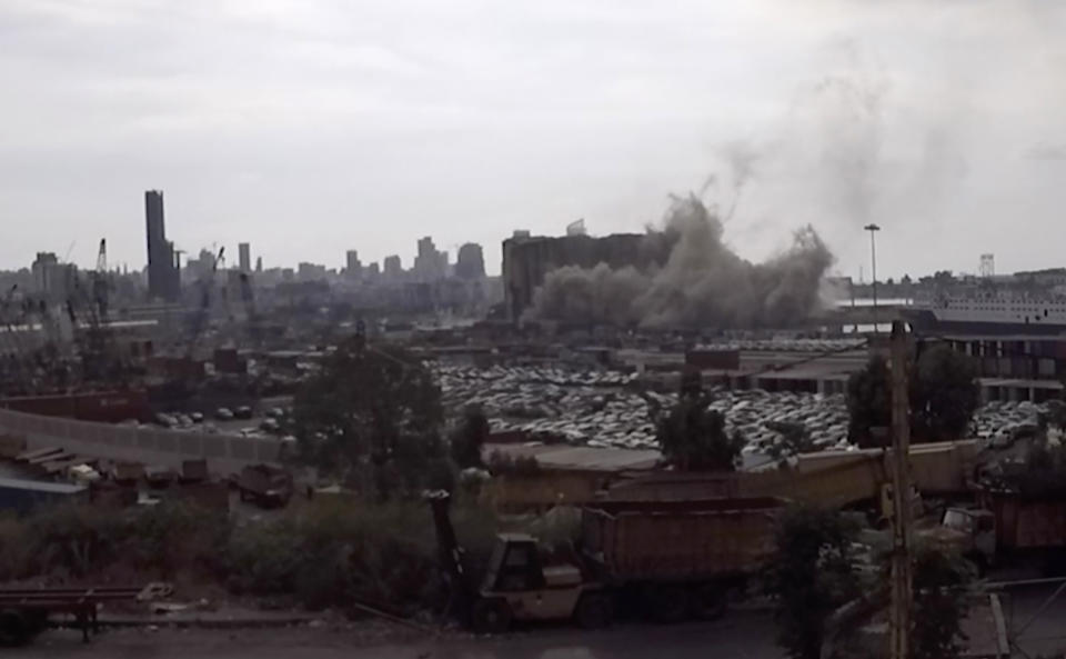 This frame grab from video shows part of the silos collapsing, in the port of Beirut, Lebanon, Sunday, July 31, 2022. A section of Beirut's massive port grain silos, shredded in the 2020 explosion, collapsed on Sunday after a weekslong fire triggered by grains that had fermented and ignited in the summer heat. (AP Photo)