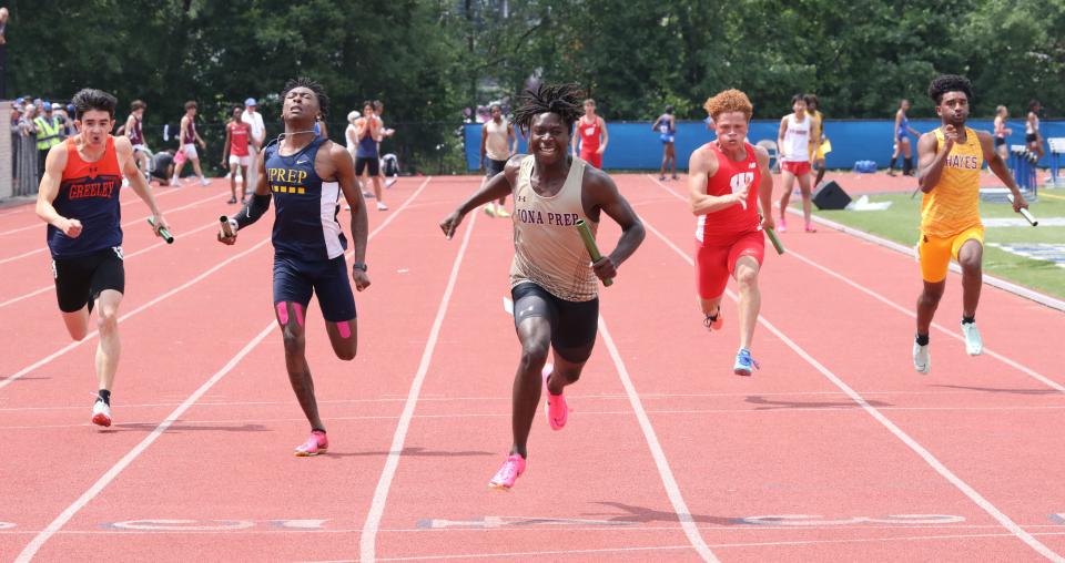 Iona Prep's Marcus Nahim crosses the finish line ahead of UPrep Rochester's OJ Singletary, left, and Horace Greeley, far left, in the boys 4x100 meter relay during the New York State Track and Field Championships at Middletown High School, June 10, 2023.