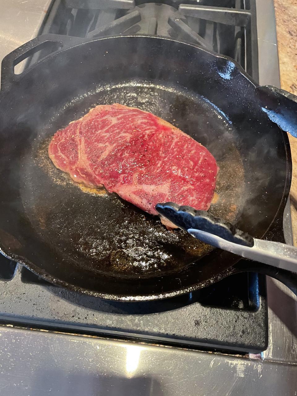 The steak should sizzle when placed in the skillet. This is a good indicator you have properly preheated your skillet. (Katie Stilo)