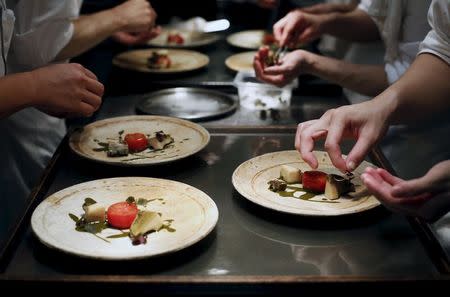 Staff of Tokyo's French restaurant Narisawa plate dishes called "Tomatoes warm in the sun, abalone and its liver? " during a special dinner event by David Kinch, the chef-owner of Manresa in Los Gatos in California, at its kitchen in Tokyo, Japan, July 9, 2015. Picture taken July 9, 2015. REUTERS/Yuya Shino