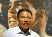 Former heavyweight world boxing champion Muhammad Ali poses with a copy of his book, The Greatest Of All Time, at the Frankfurt book fair October 9, 2003. REUTERS/Kai Pfaffenbach/File Photo