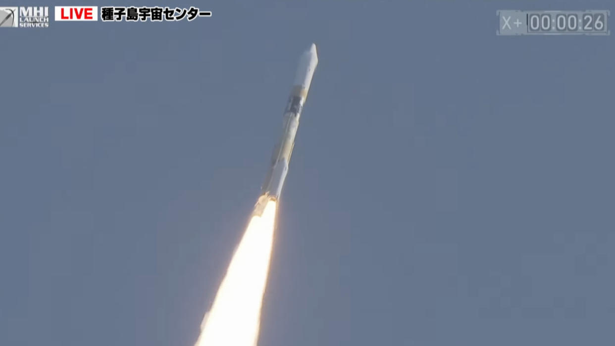  a white rocket launches into a blue sky. 