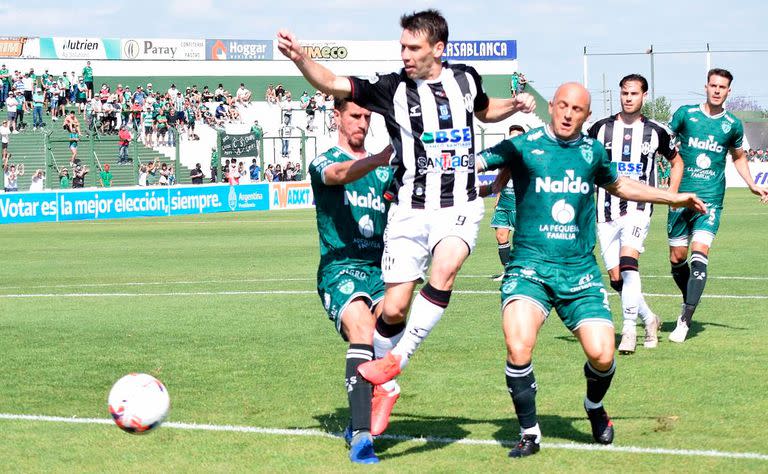 Claudio Riaño intenta pasar entre Mancinelli; escena del partido entre Central Córdoba y Sarmiento