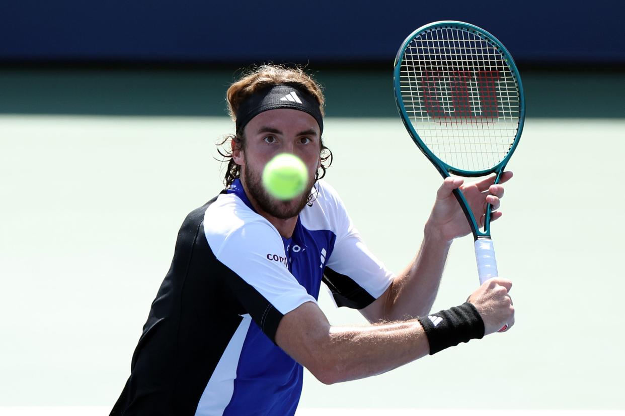 Stefanos Tsitsipas returns against Thanasi Kokkinakis during their four-set match at the U.S. Open.