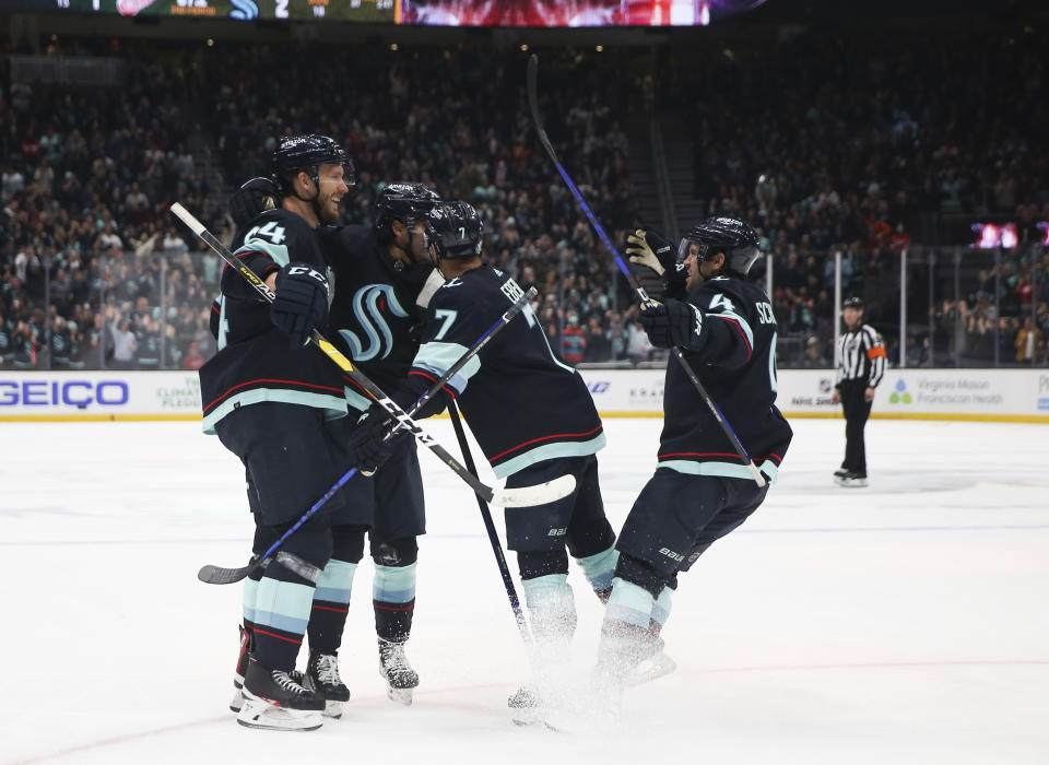 Seattle Kraken defenseman Jamie Oleksiak, left, celebrates with teammates, including right wing Jordan Eberle (7), after scoring a goal against the Detroit Red Wings during the second period of an NHL hockey game Saturday, Feb. 18, 2023, in Seattle. (AP Photo/ Lindsey Wasson)