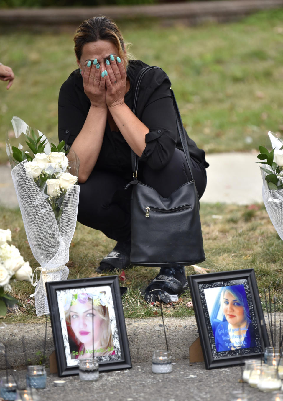 Close-family friend Zena Abbo cries at the makeshift memorial of her friend, Saja Aljanabi Sunday, Sept. 8, 2019, as they light candles around her memorial in Dearborn, Mich. Dearborn Police Chief Ronald Haddad said Thursday, Sept. 12, 2019, that the 14-year-old, a 13-year-old and 17-year-old are being held in connection with last week's killing of Saja Aljanabi and they could be involved in other crimes in the area. (Todd McInturf/Detroit News via AP)