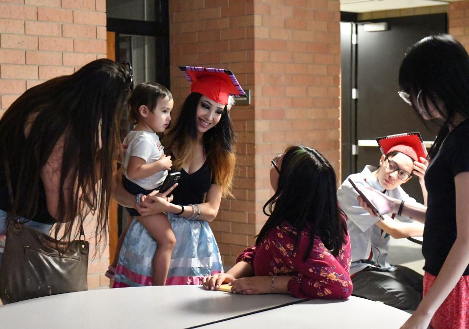 Delicia Rouse, Lincoln graduate, holds her daughter, Kailani Eagle Deer, after a celebration for Native American students graduating from Sioux Falls public schools on Friday, May 27, 2022, at Washington High School.