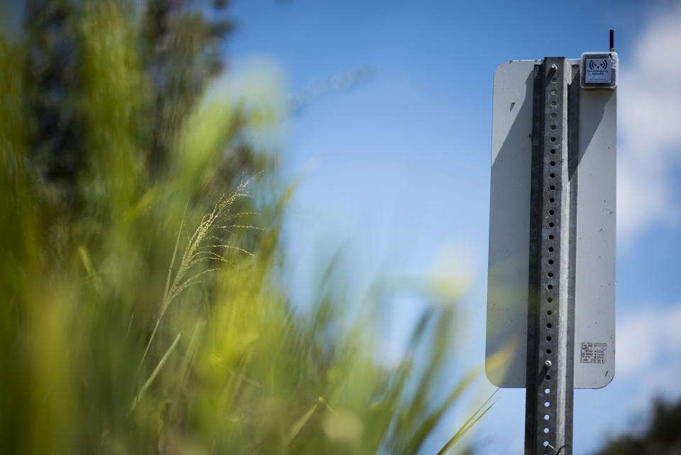 This March 13, 2019 photo shows a transmitter that is part of a system that provides a low-frequency Wi-Fi connection, on the back of a traffic sign, during a field test in Isabela, Puerto Rico. The transmitters are powered by batteries and maybe eventually solar power. (AP Photo/Carlos Giusti)