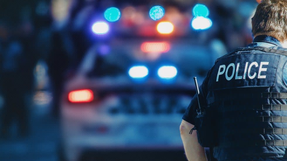 A police officer in front of a police car