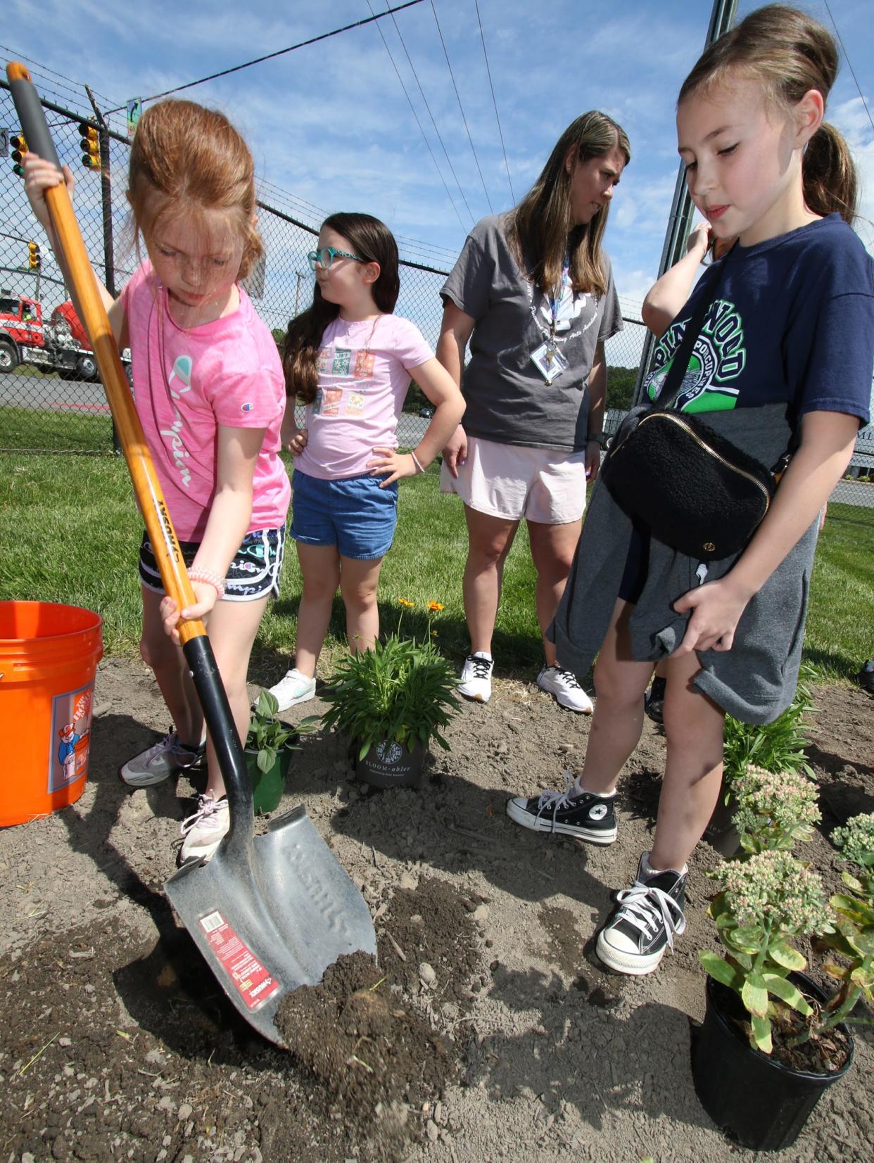 Fourth graders Zoey Teems, Lilly Bryson and Merritt Jones work to dig a hole during an Earth Day event held Friday afternoon, April 19, 2024, at Daimler in Mount Holly.