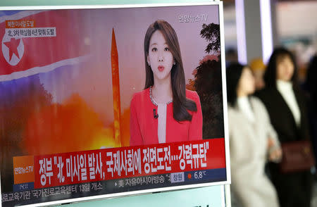 Women walk past a TV screen broadcasting a news report on North Korea firing a ballistic missile into the sea off its east coast, at a railway station in Seoul, South Korea, February 12, 2017. REUTERS/Kim Hong-Ji