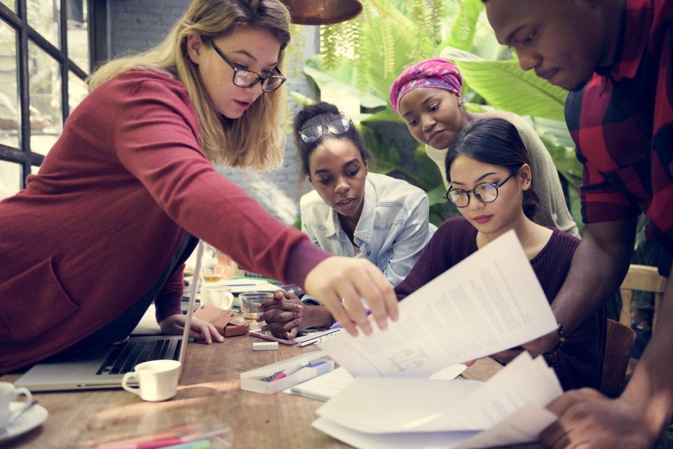 Group of young workers, look at a document.