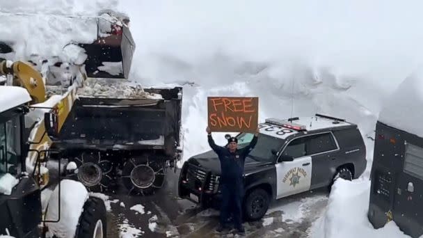 PHOTO: In this screen grab from a video posted on March 3, 2023, to the CHP Truckee Twitter account, an officer holds up a 'Free Snow' sign as a truck removes snow from the area in Truckee, Calif. (@CHP_Truckee/Twitter)