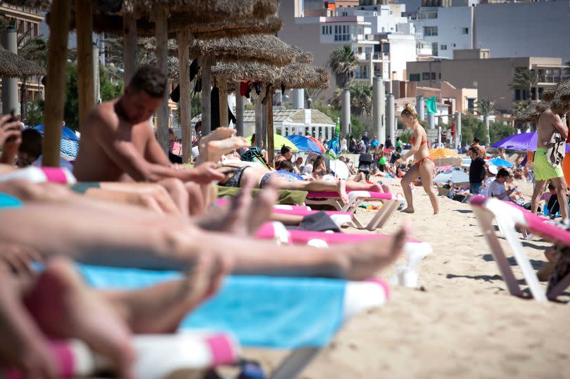 Tourists sunbathe on the beach at the Spanish Balearic Island of Mallorca