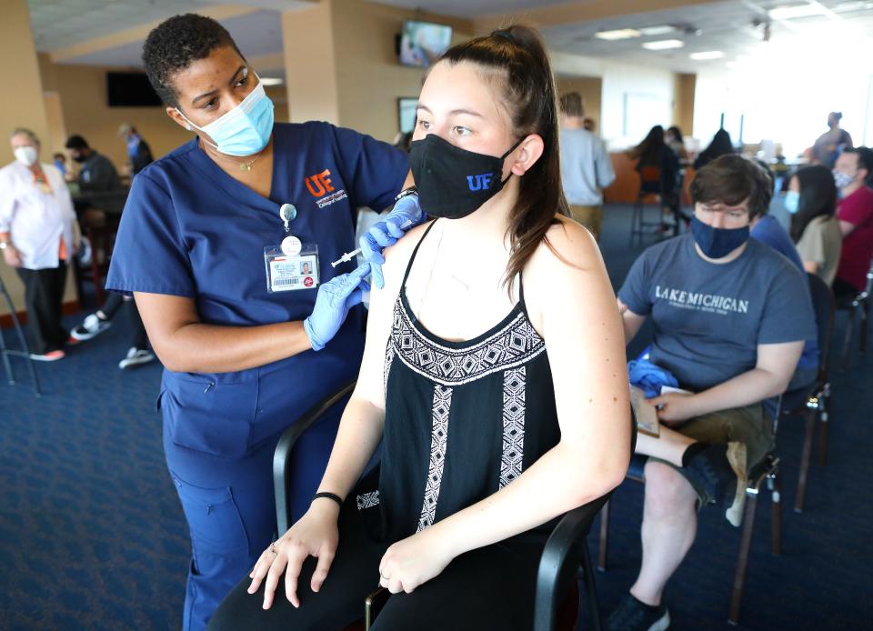 Catalina Pike, right, a University of Florida freshman, prepares to get her COVID-19 vaccine from UF senior nursing student Kayla Elliott during a mass vaccination effort by the University of Florida held at Ben Hill Griffin Stadium in Gainesville Fla. April 5, 2021.  [Brad McClenny/The Gainesville Sun]