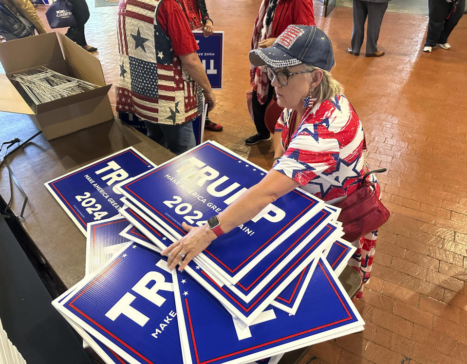 Ginger Hurmence of Lincolnton, Ga., picks up Republican presidential candidate Donald Trump yard signs at the Georgia Republican Party State Convention in Columbus, Ga., on Saturday, May 18, 2024. (AP Photo/Jeff Amy)