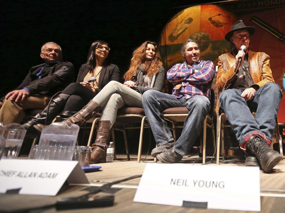 Musician Neil Young (R) addresses the media while flanked by limnologist David Schindler (L-2nd R), Athabasca Chipewyan First Nation (ACFN) Communications Coordinator Eriel Deranger, ACFN Industry Relation Corporation Consultation Coordinator Doreen Somers and ACFN Chief Allan Adam, before the "Honor The Treaties" concert series at the Centennial Concert Hall in Winnipeg, Manitoba, January 16, 2014. Young is touring to raise money for the aboriginal group, which is trying to prevent the expansion of tar sands development. REUTERS/Trevor Hagan (CANADA - Tags: POLITICS ENTERTAINMENT ENVIRONMENT ENERGY SOCIETY)